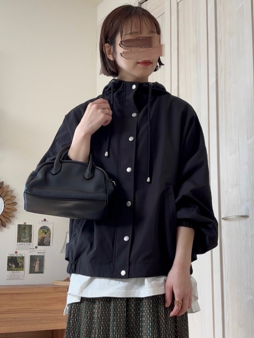 ホワイト系のマウンテンパーカー、グリーン系のスカートを着用したレディースの春コーディネートの3枚目の写真