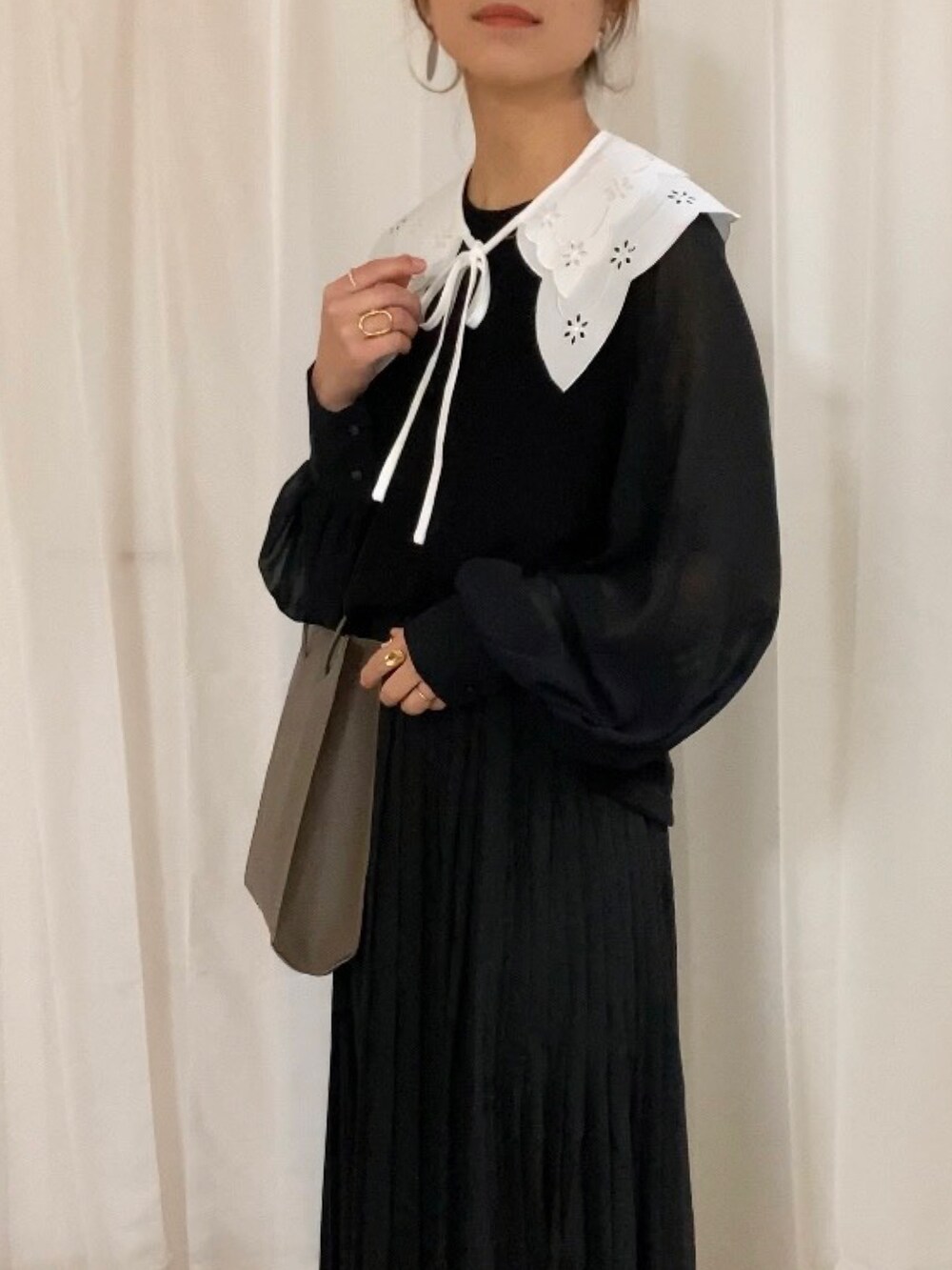 ブラック系のTシャツ/カットソー、ブラウン系のトートバッグ、レッド系のブーツを着用したレディースの冬コーディネートの2枚目の写真
