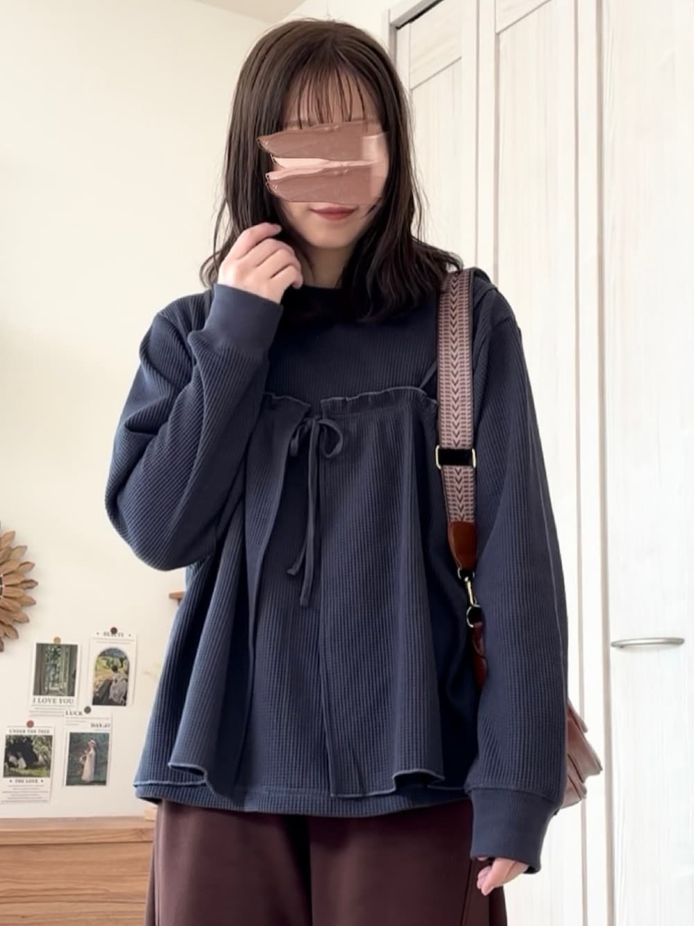 グレー系のアンサンブル、ブラウン系のショルダーバッグを着用したレディースの冬コーディネートの2枚目の写真