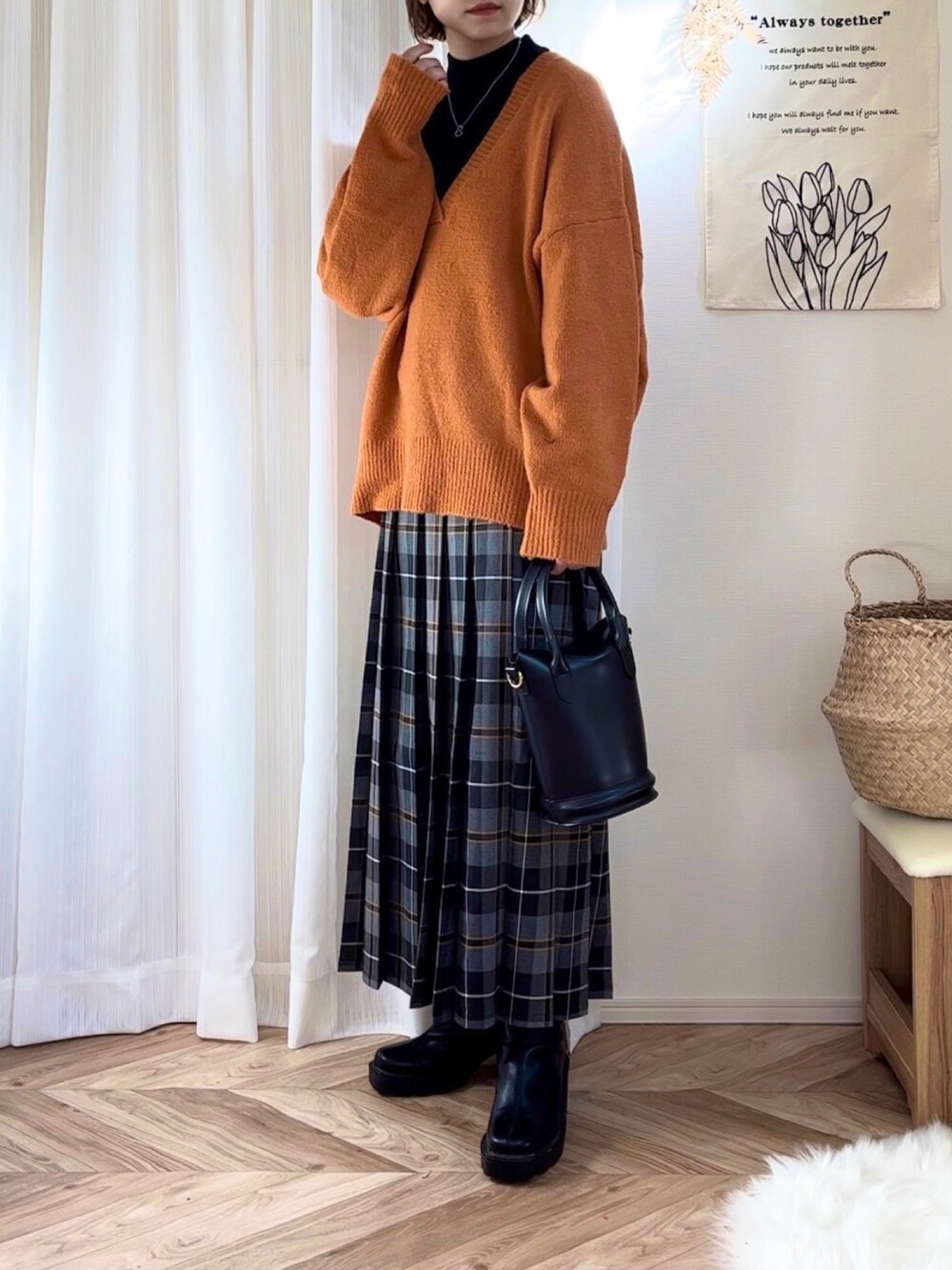 ブラック系のダウンジャケット/コート、オレンジ系のニット/セーター、ブラック系のニット/セーターを着用したレディースの冬コーディネートの2枚目の写真