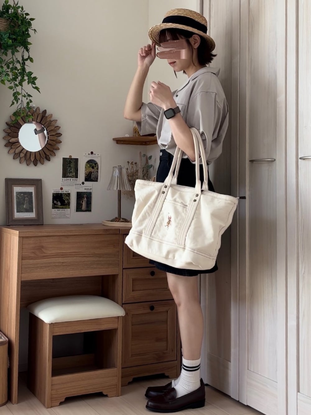 ベージュ系のシャツ/ブラウス、ブラック系のデニムスカート、ホワイト系のトートバッグを着用したレディースの夏コーディネートの2枚目の写真