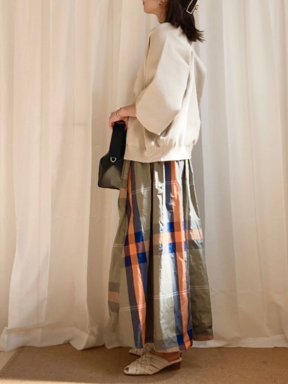 ホワイト系のカーディガン/ボレロ、ホワイト系のキャミソール、グリーン系のスカートを着用したレディースの春コーディネートの2枚目の写真