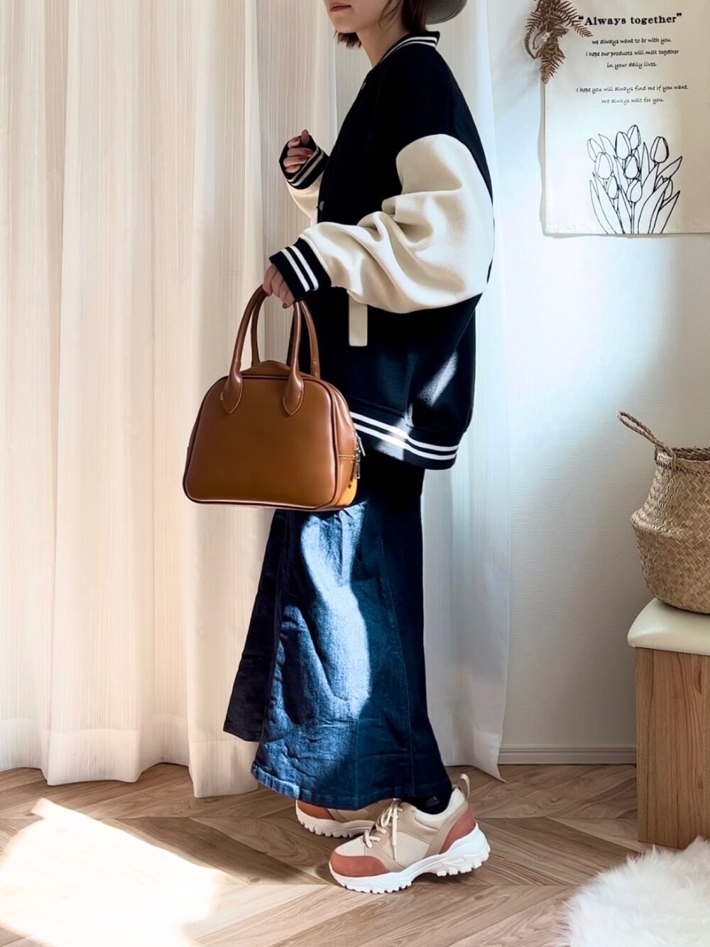 ホワイト系のTシャツ/カットソー、ブラック系のスタジャン、イエロー系のボストンバッグを着用したレディースの秋コーディネートの2枚目の写真