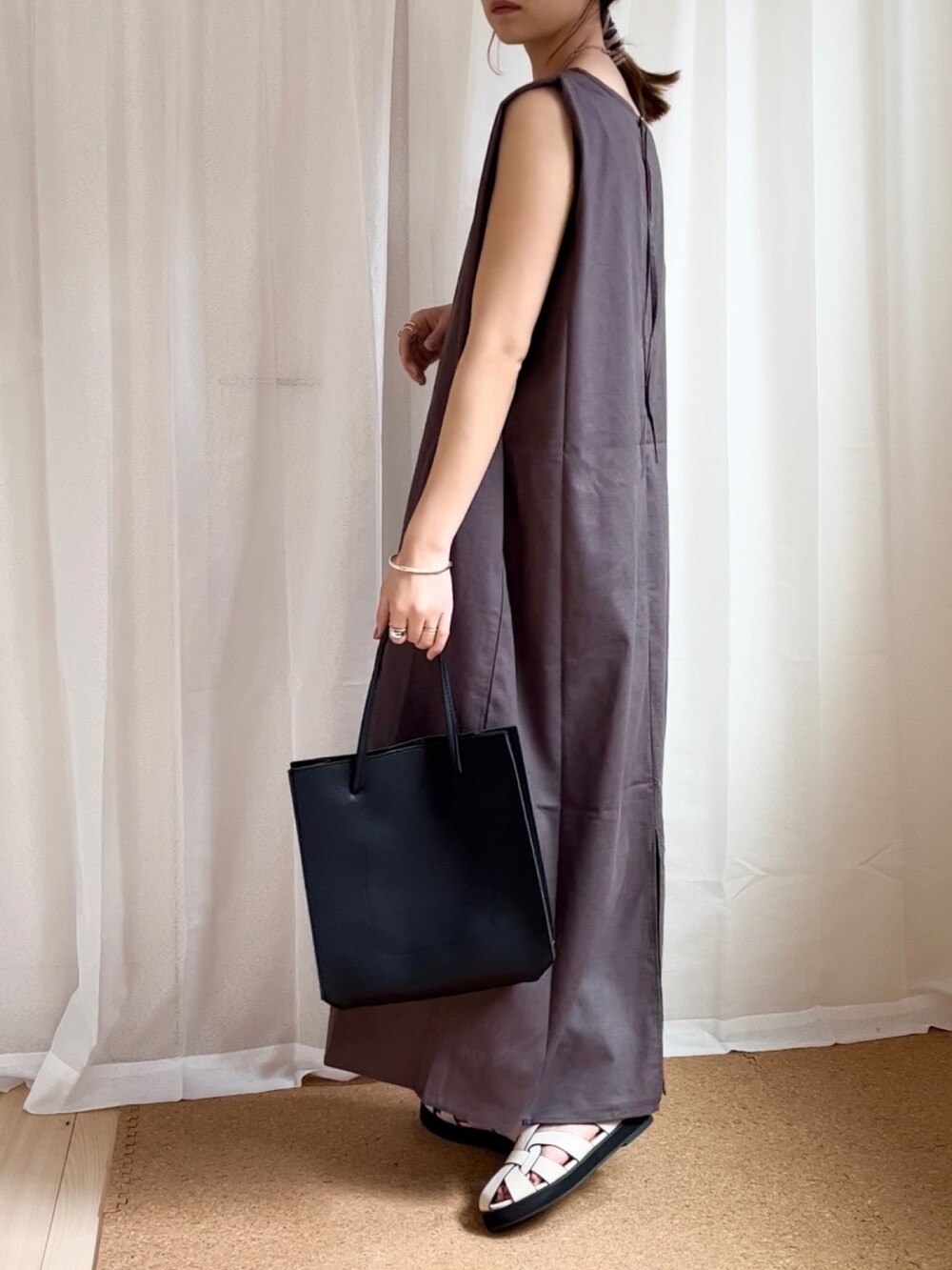 グレー系のワンピース、ブラック系のトートバッグ、ベージュ系のサンダルを着用したレディースの夏コーディネートの2枚目の写真