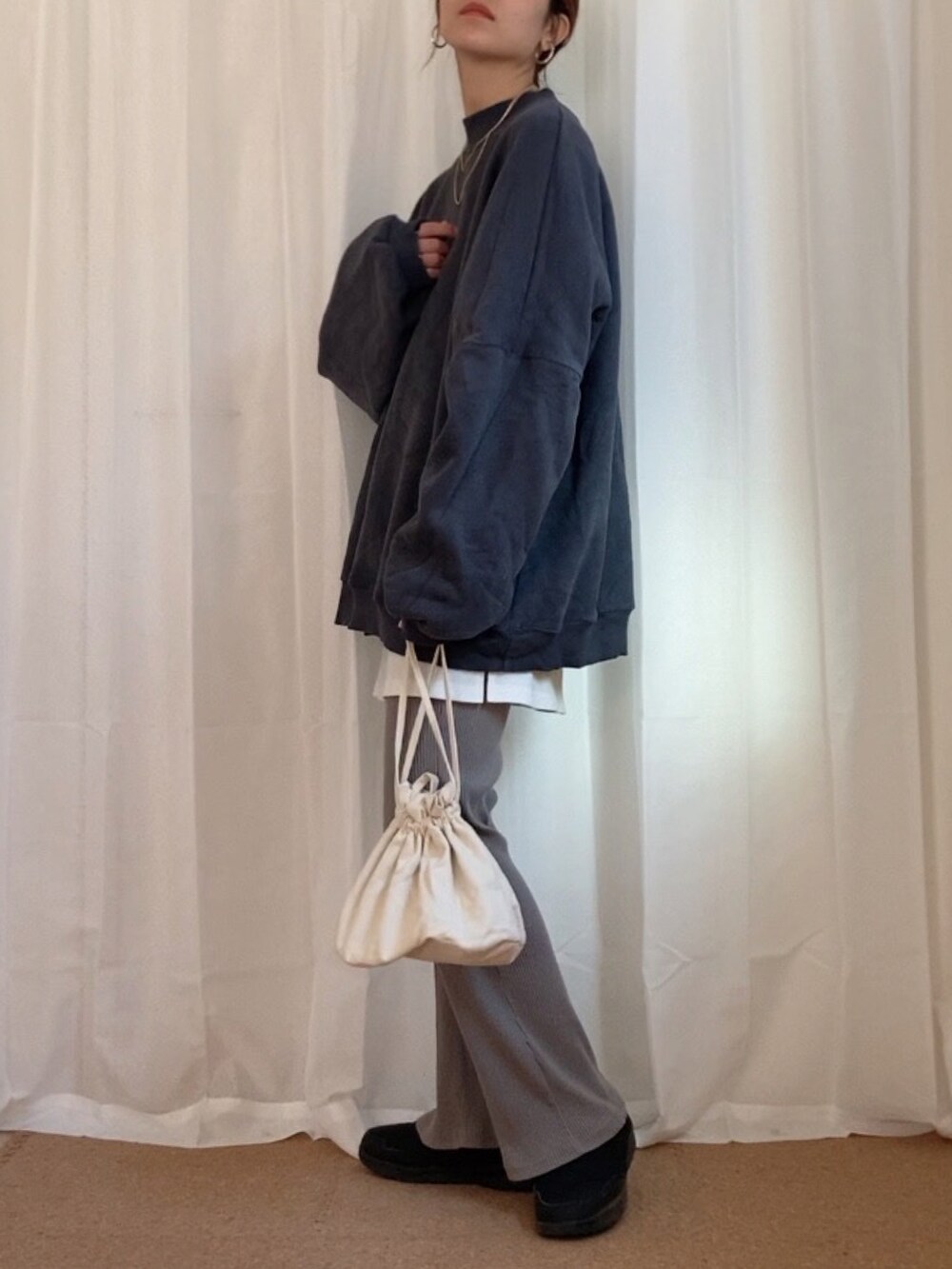 グレー系のスウェット、ホワイト系のショルダーバッグ、ブラック系のシューズを着用したレディースの秋コーディネートの2枚目の写真