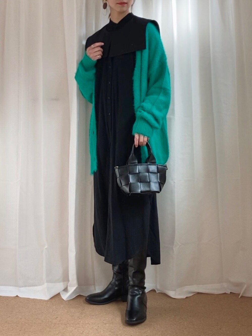 グリーン系のカーディガン/ボレロ、ブラック系のシャツワンピース、ブラック系のバッグを着用したレディースの冬コーディネートの2枚目の写真