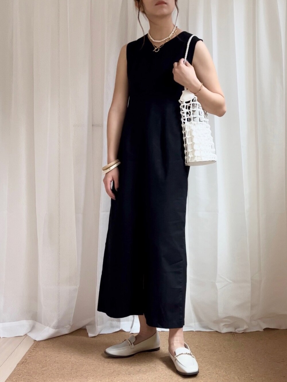 ブラック系のワンピース、ホワイト系のローファー、ホワイト系のネックレスを着用したレディースの春コーディネートの3枚目の写真