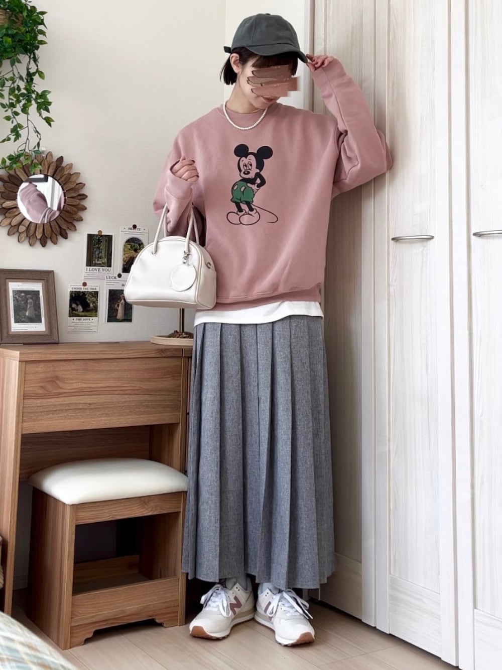 ピンク系のスウェット、ブラウン系のスカート、ホワイト系のボストンバッグを着用したレディースの春コーディネートの3枚目の写真