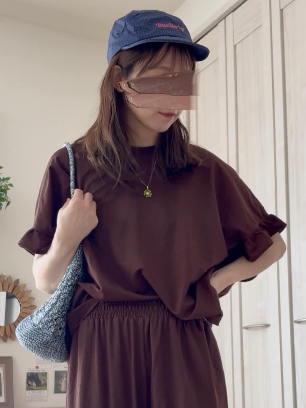 ブルー系のかごバッグ、ブラウン系のTシャツ/カットソー、ブラウン系のその他パンツを着用したレディースの夏コーディネートの3枚目の写真
