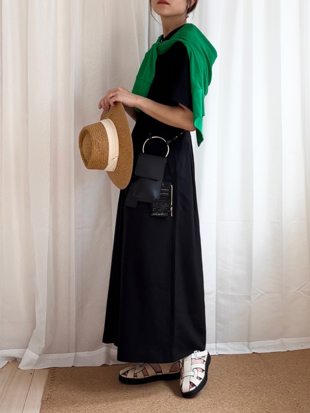 ブラック系のワンピース、グリーン系のカーディガン/ボレロ、ブラック系のショルダーバッグを着用したレディースの夏コーディネートの2枚目の写真