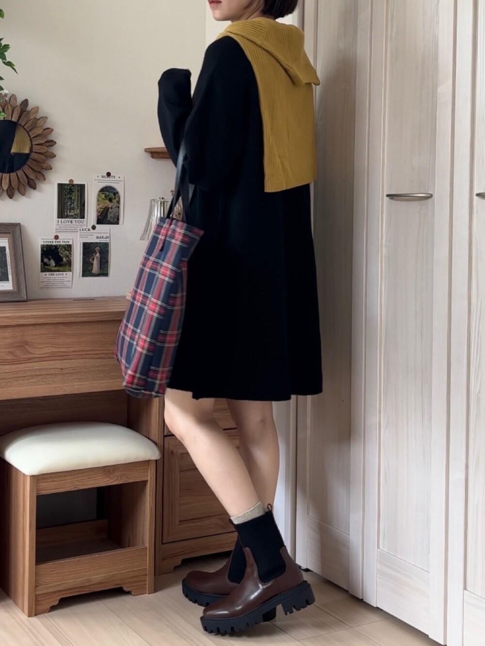 ブラック系のワンピース、ブラウン系のブーツを着用したレディースの秋コーディネートの4枚目の写真