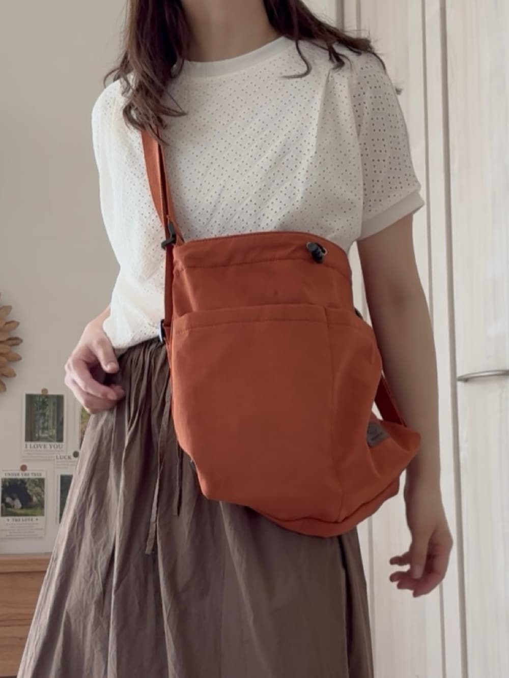 オレンジ系のバックパック/リュック、ホワイト系のTシャツ/カットソーを着用したレディースの夏コーディネートの4枚目の写真