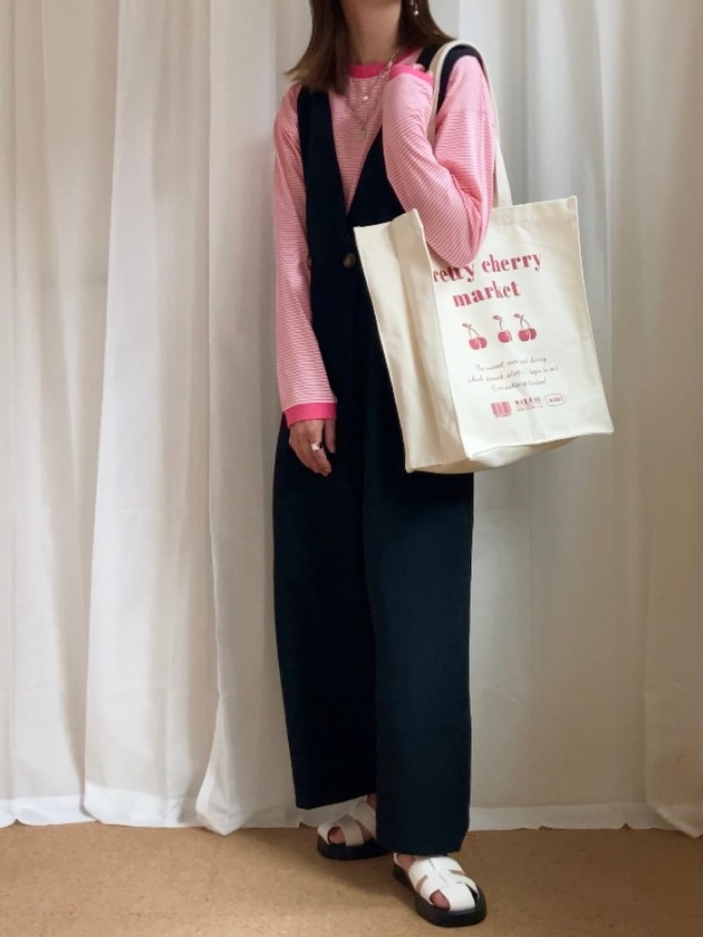 ブラック系のサロペット/オーバーオール、ピンク系のTシャツ/カットソー、その他のトートバッグを着用したレディースの春コーディネートの2枚目の写真