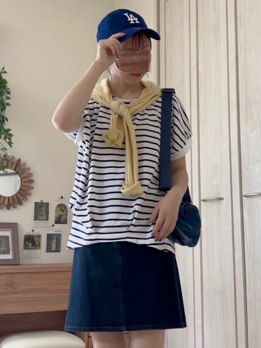 ホワイト系のTシャツ/カットソー、ブラック系のバレエシューズ、ブルー系のデニムスカートを着用したレディースの夏コーディネートの2枚目の写真