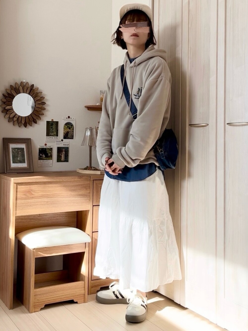 ベージュ系のパーカー、ホワイト系のスカート、ブルー系のショルダーバッグを着用したレディースの春コーディネートの4枚目の写真