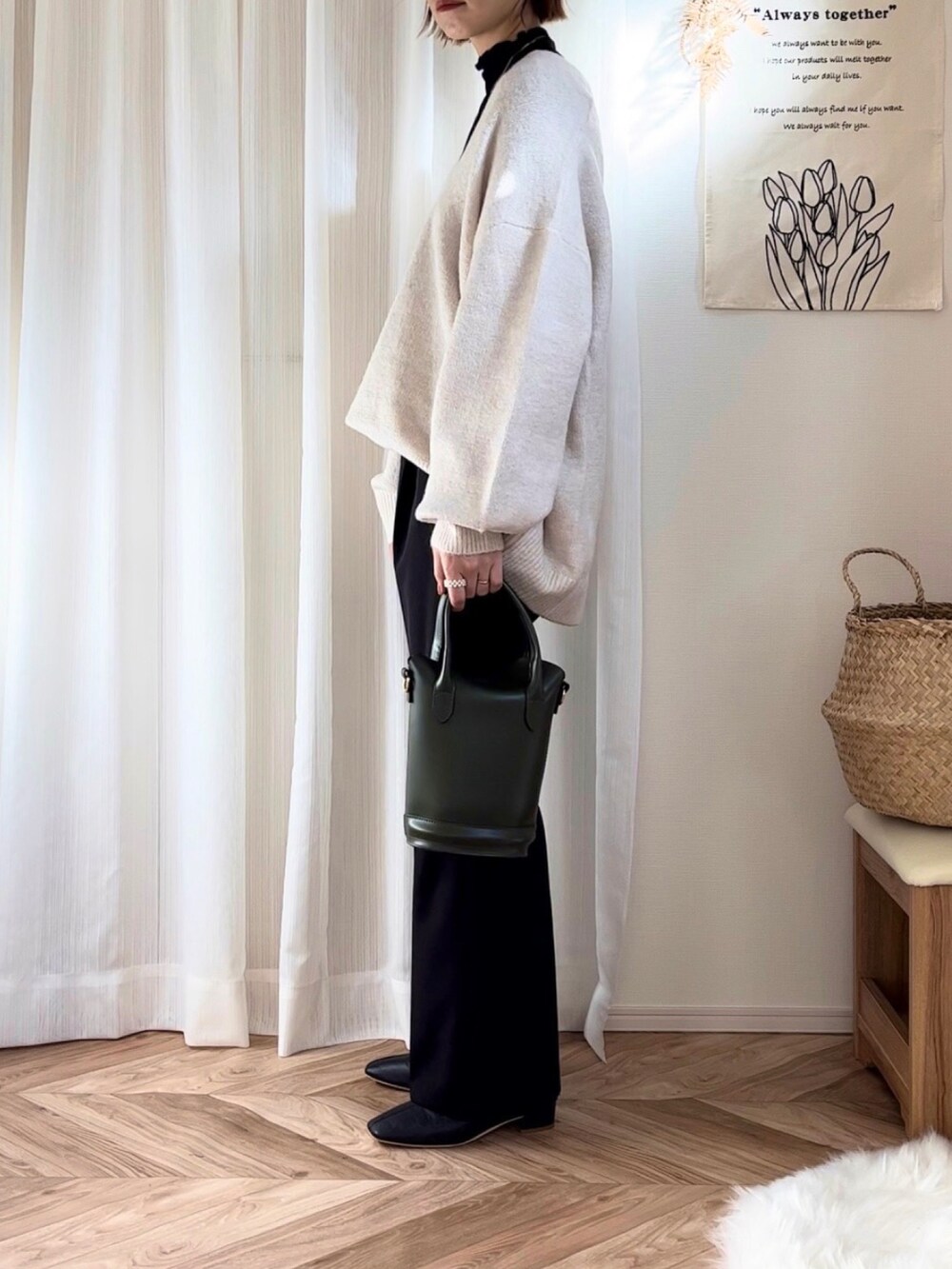 ベージュ系のニット/セーター、ブラック系のその他アウター、ブラック系のブーツを着用したレディースの冬コーディネートの2枚目の写真