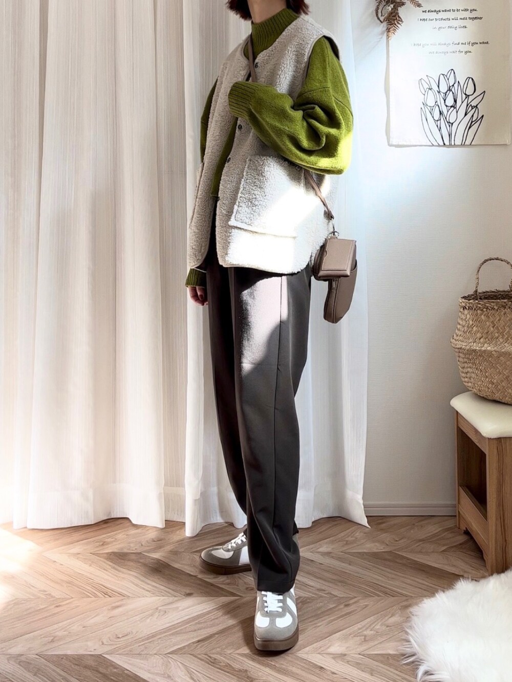 グリーン系のニット/セーター、ベージュ系のベスト、ブラウン系のスラックスを着用したレディースの秋コーディネートの2枚目の写真