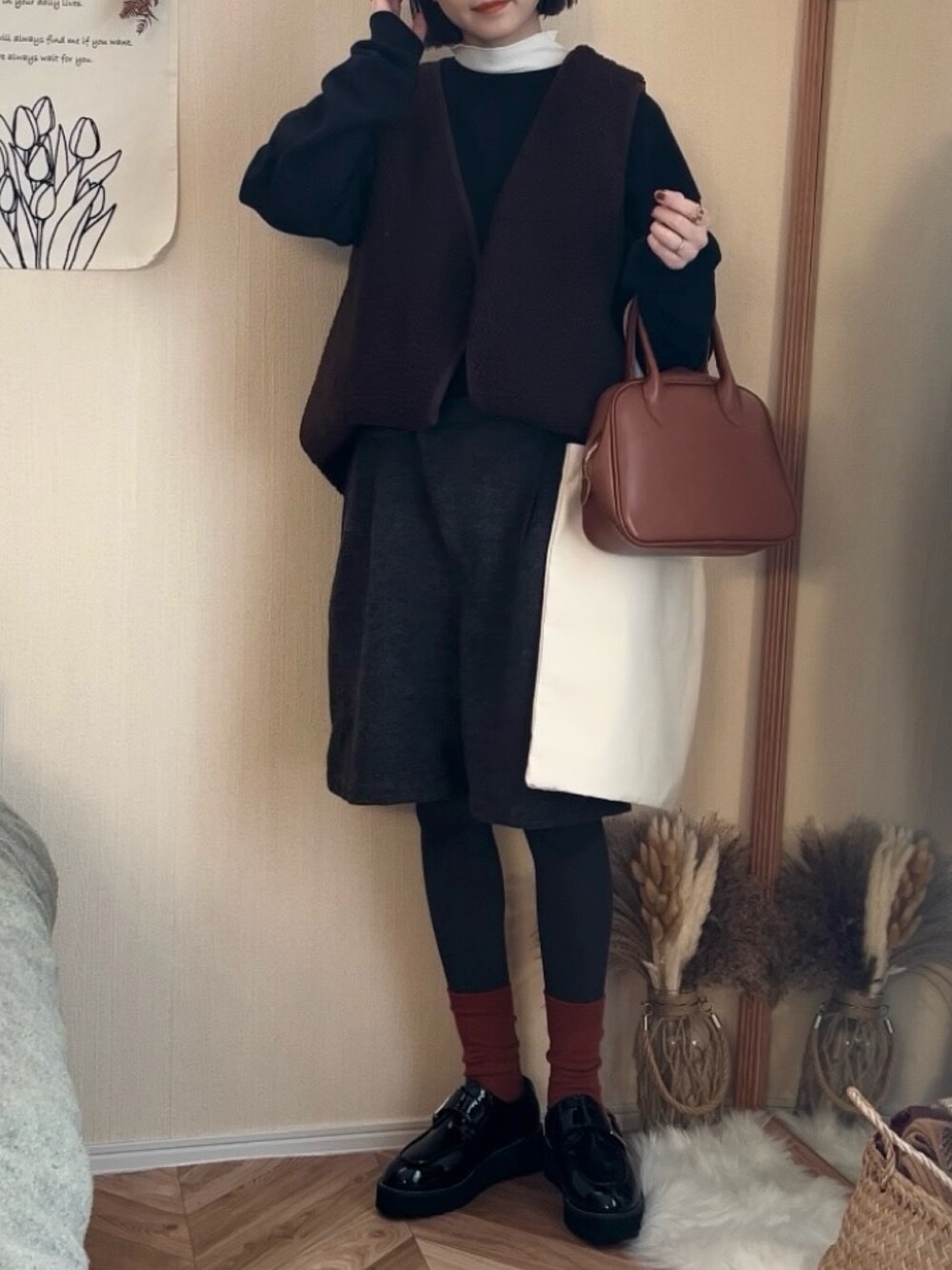 ブラック系のスウェット、ブラウン系のベスト、ブラウン系のその他パンツを着用したレディースの冬コーディネートの3枚目の写真