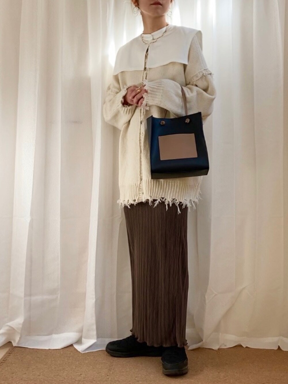 ホワイト系のニット/セーター、ホワイト系のシャツ/ブラウス、ブラウン系のスカートを着用したレディースの冬コーディネートの3枚目の写真