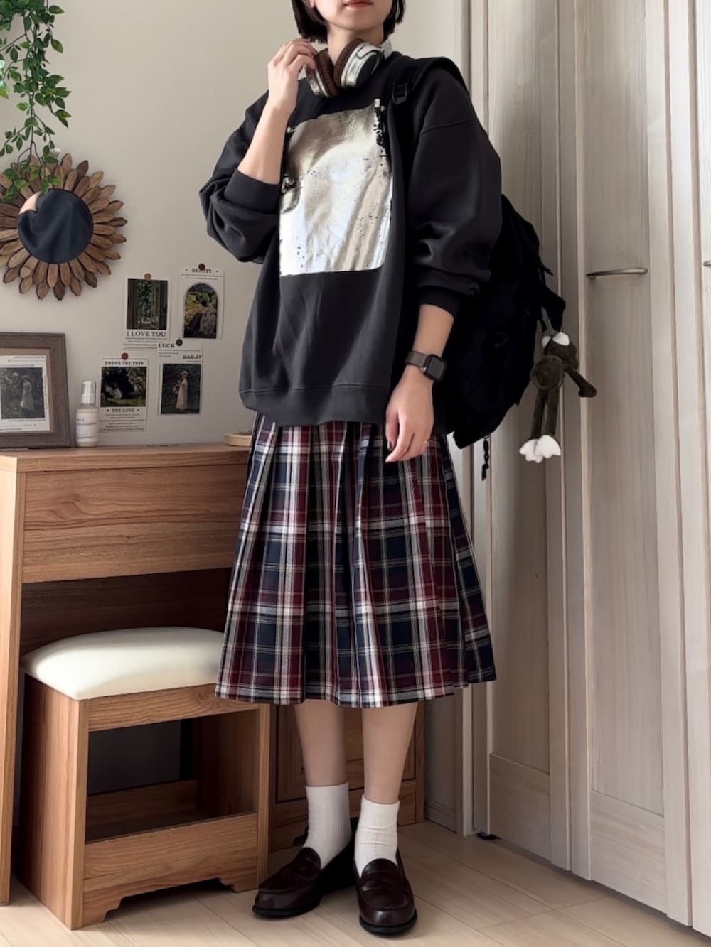 ブラック系のスウェット、ブルー系のスカート、ブラウン系のローファーを着用したレディースの秋コーディネートの3枚目の写真