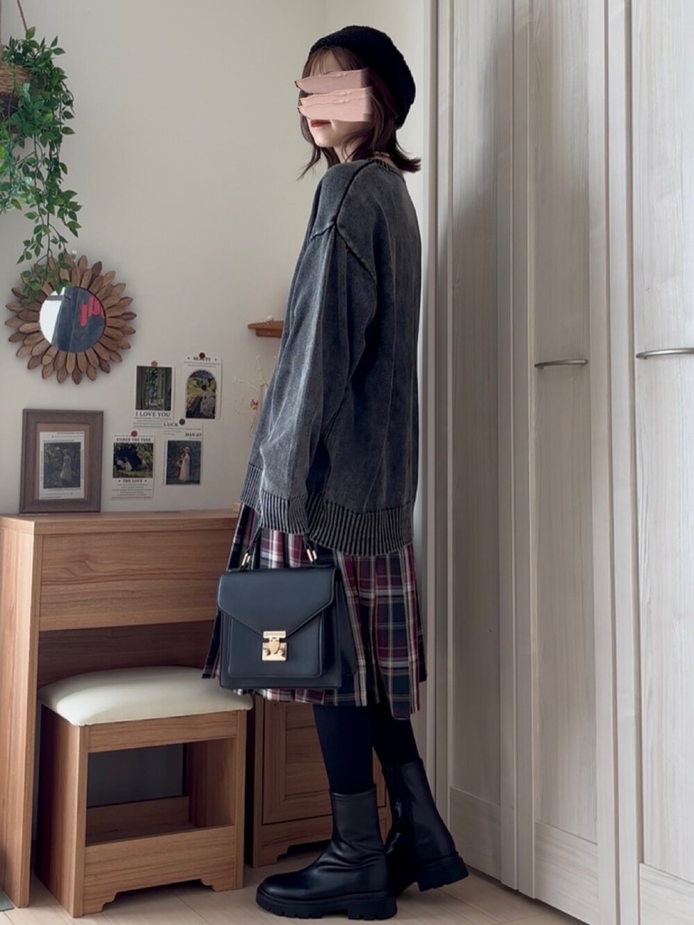 ブラック系のニット/セーター、ブラック系のブーツ、ブルー系のスカートを着用したレディースの秋コーディネートの3枚目の写真