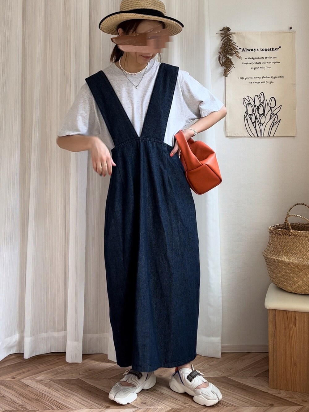 ベージュ系のTシャツ/カットソー、ブルー系のジャンパースカート、オレンジ系のハンドバッグを着用したレディースの夏コーディネートの2枚目の写真