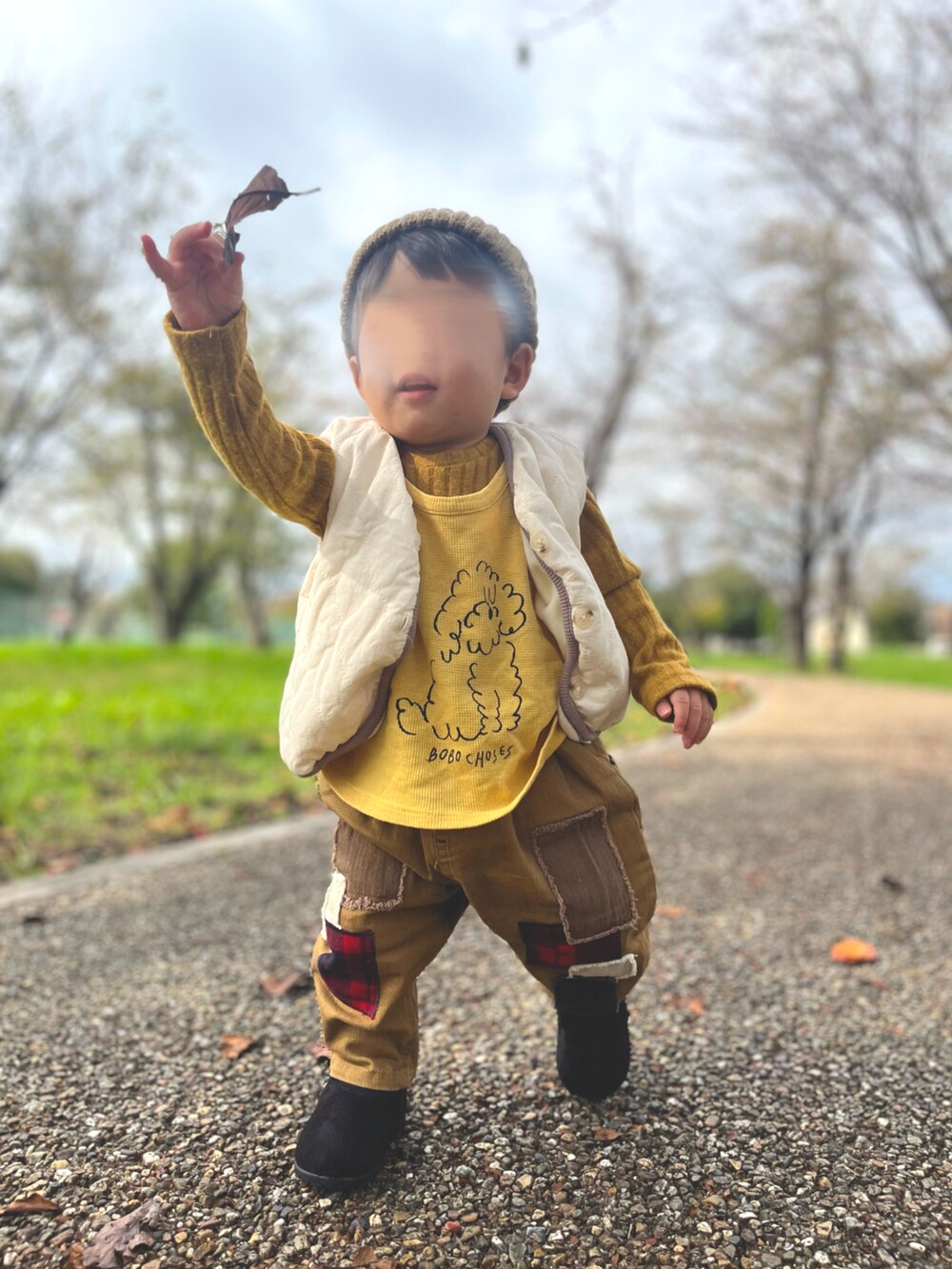 イエロー系のトップス、イエロー系のベスト、ベージュ系のその他パンツを着用したキッズの秋コーディネートの2枚目の写真