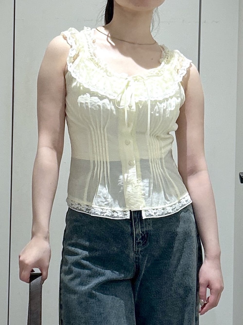ブラウン系のサンダル、ブルー系のデニムパンツ、イエロー系のシャツ/ブラウスを着用したレディースの夏コーディネートの4枚目の写真