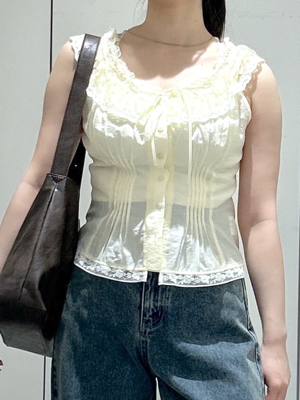 ブラウン系のサンダル、ブルー系のデニムパンツ、イエロー系のシャツ/ブラウスを着用したレディースの夏コーディネートの7枚目の写真