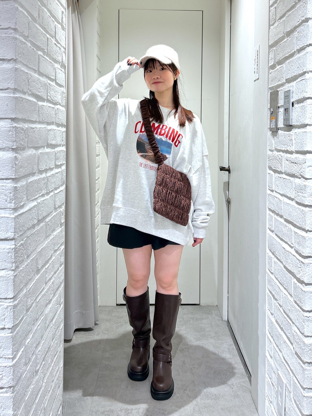 ホワイト系のスウェット、ブラック系のその他パンツ、ブラウン系のブーツを着用したレディースの秋コーディネートの2枚目の写真