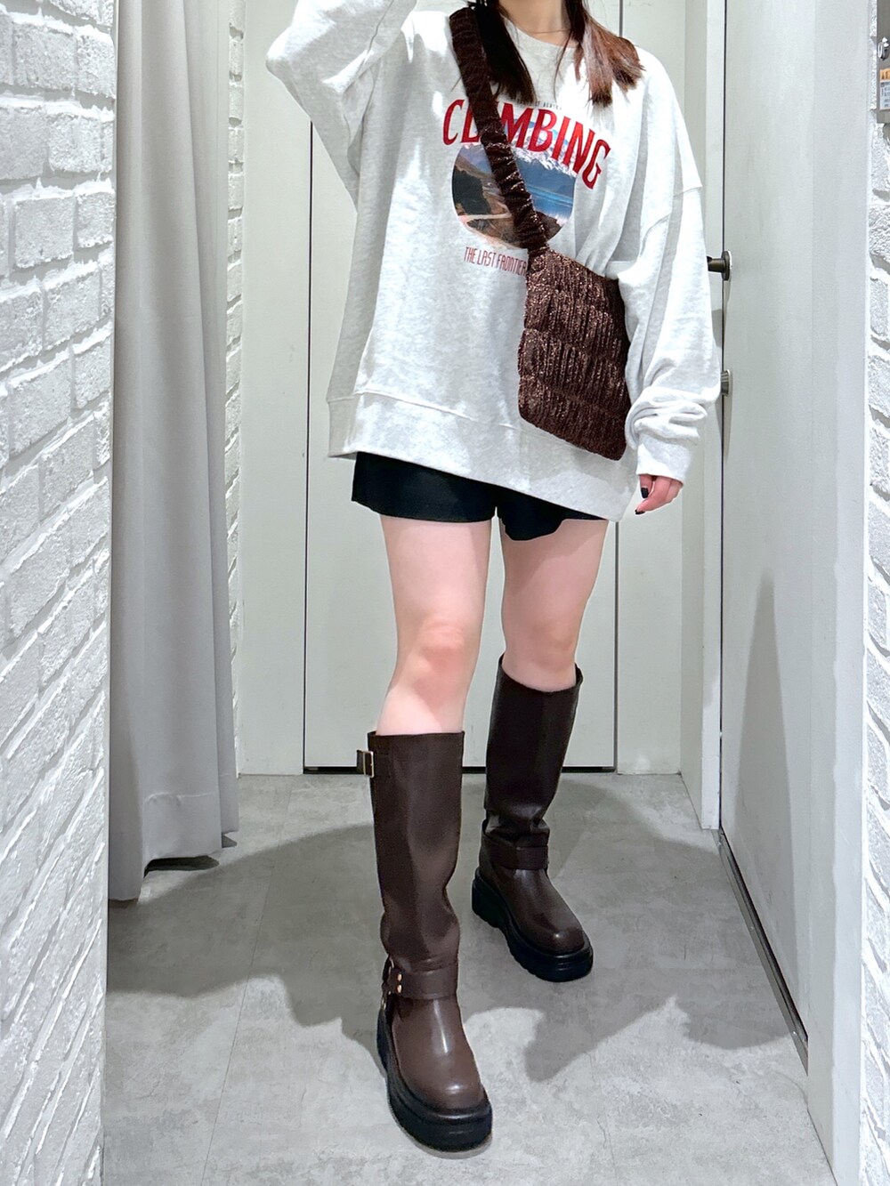 ホワイト系のスウェット、ブラック系のその他パンツ、ブラウン系のブーツを着用したレディースの秋コーディネートの3枚目の写真