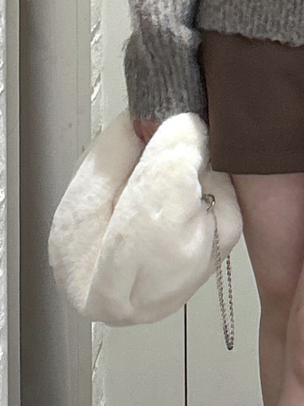 ブラウン系のその他パンツ、ブラウン系のブーツ、ホワイト系のハンドバッグを着用したレディースの冬コーディネートの8枚目の写真