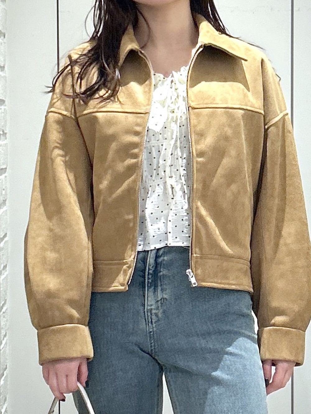 ブラック系のローファー、ブルー系のデニムパンツ、ホワイト系のトートバッグを着用したレディースの冬コーディネートの5枚目の写真