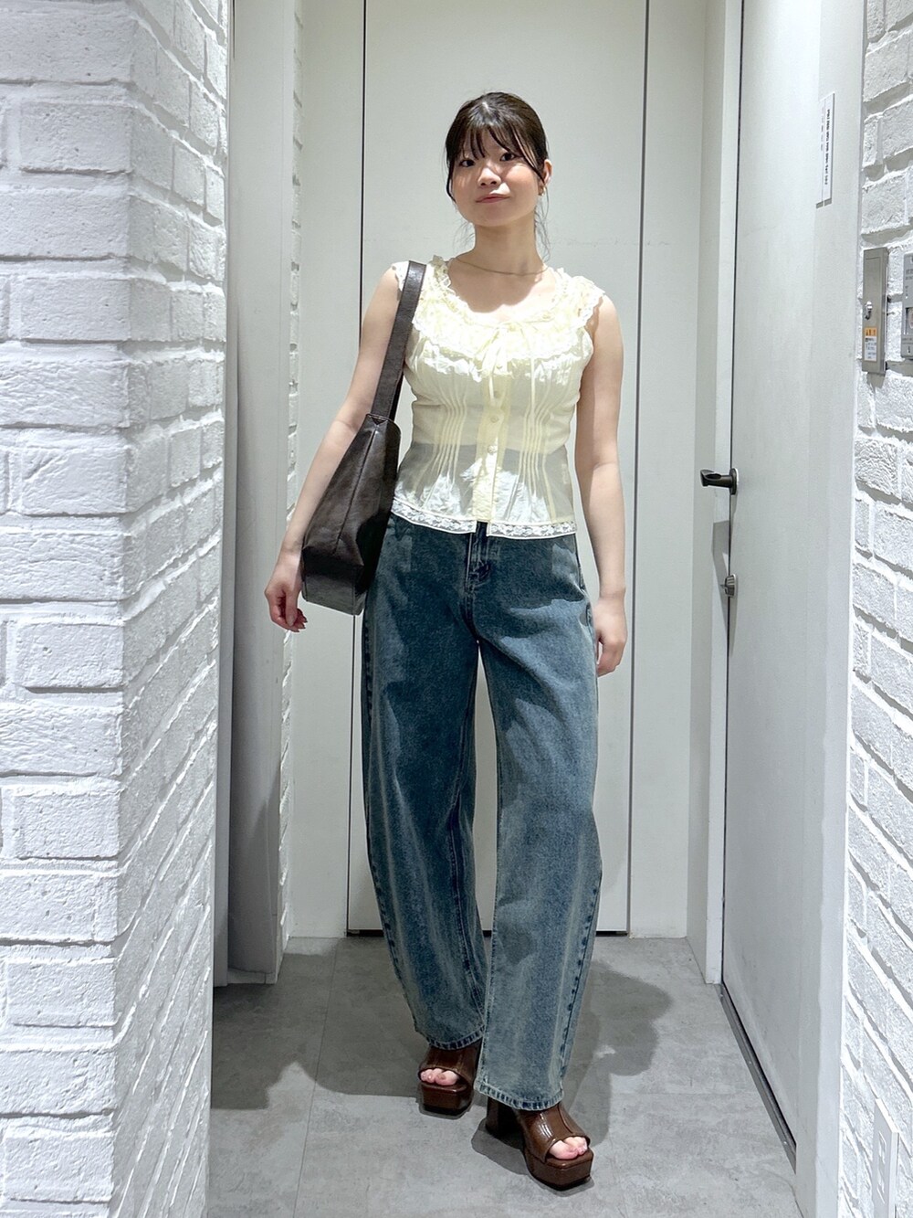 ブラウン系のサンダル、ブルー系のデニムパンツ、イエロー系のシャツ/ブラウスを着用したレディースの夏コーディネートの6枚目の写真