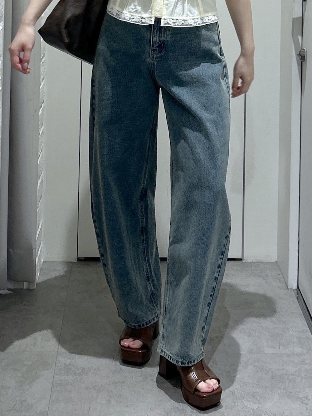 ブラウン系のサンダル、ブルー系のデニムパンツ、イエロー系のシャツ/ブラウスを着用したレディースの夏コーディネートの5枚目の写真