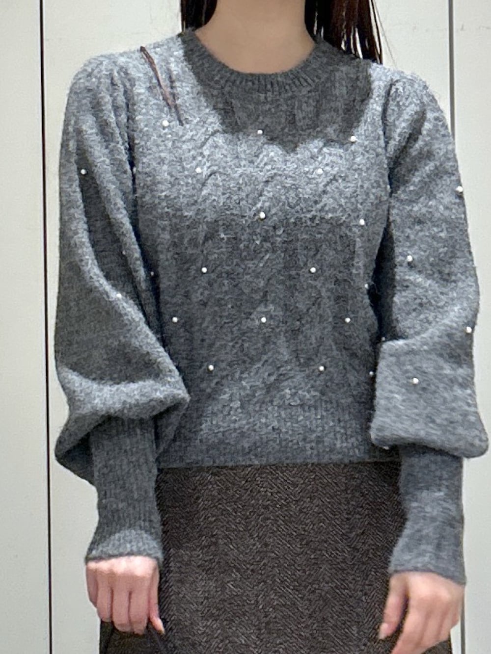 ブラック系のトートバッグ、ブラック系のブーツ、ブラウン系のスカートを着用したレディースの秋コーディネートの5枚目の写真