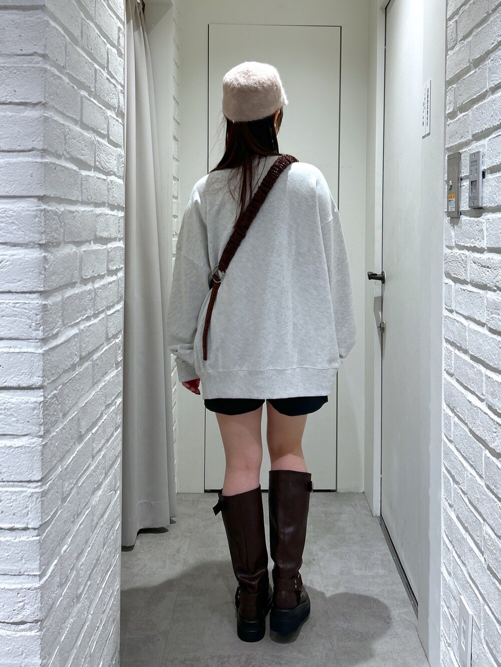 ホワイト系のスウェット、ブラック系のその他パンツ、ブラウン系のブーツを着用したレディースの秋コーディネートの4枚目の写真