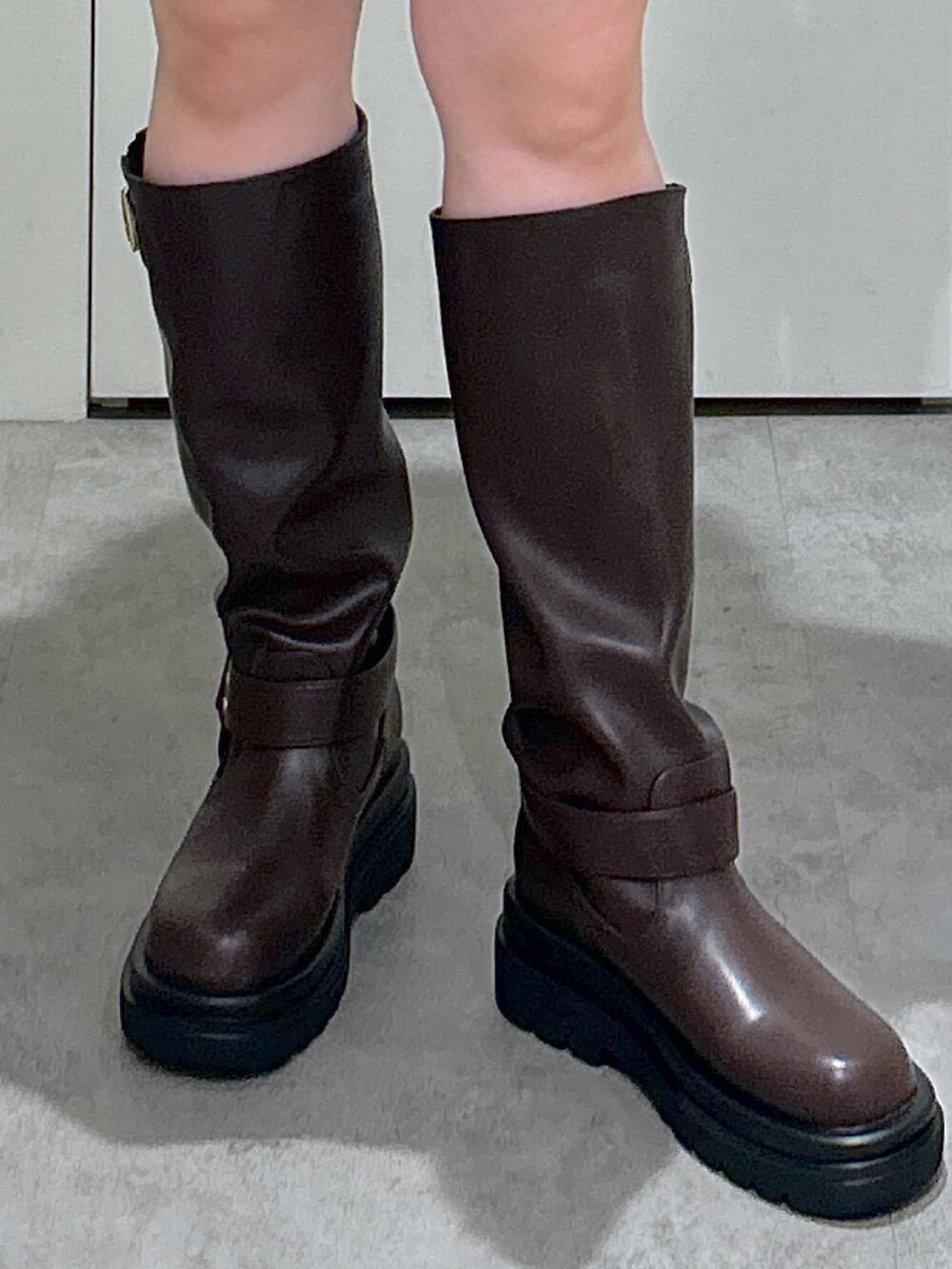 ホワイト系のスウェット、ブラック系のその他パンツ、ブラウン系のブーツを着用したレディースの秋コーディネートの9枚目の写真