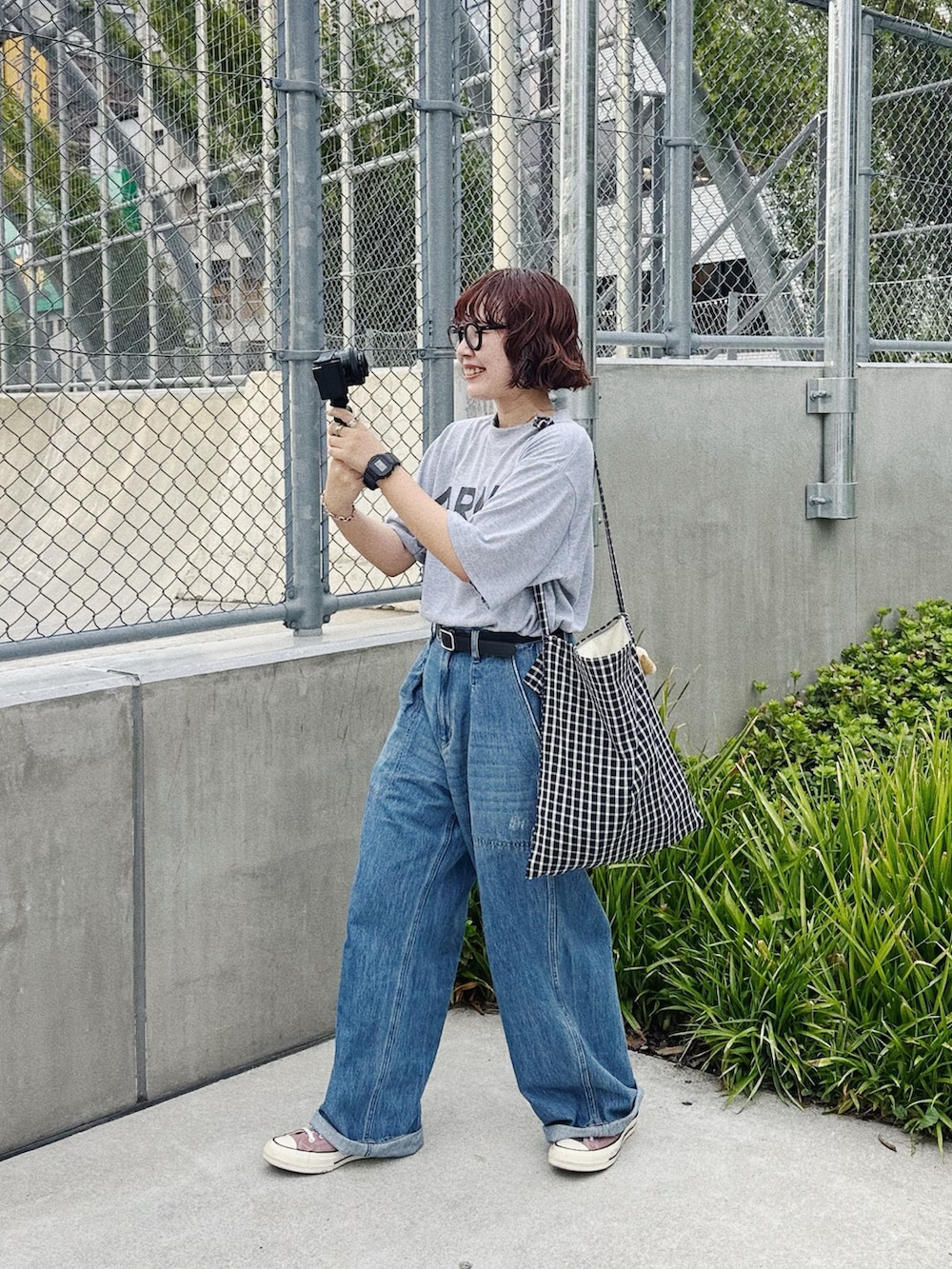 グレー系のTシャツ/カットソー、ブルー系のデニムパンツ、ブラック系のベルトを着用したレディースの秋コーディネートの4枚目の写真