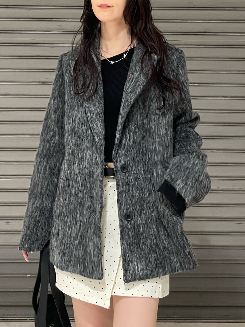 ブラック系のニット/セーター、グレー系のその他アウター、ホワイト系のスカートを着用したレディースの冬コーディネートの4枚目の写真