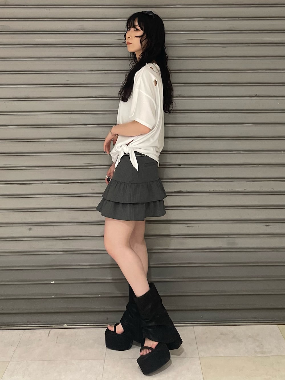 ホワイト系のTシャツ/カットソー、グレー系のスカート、ブラック系のサンダルを着用したレディースの夏コーディネートの2枚目の写真