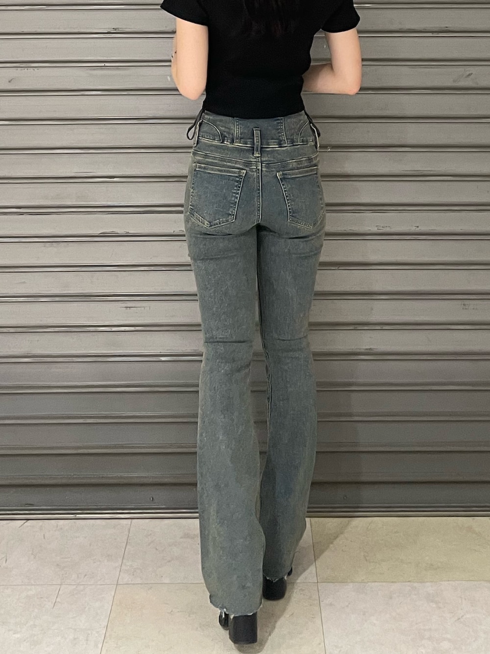 ブラック系のTシャツ/カットソー、ブルー系のデニムパンツ、ブラック系のサンダルを着用したレディースの春コーディネートの7枚目の写真