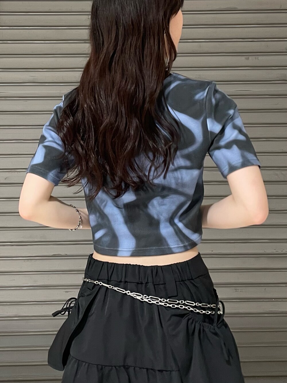 ブルー系のTシャツ/カットソー、ブラック系のスカート、ブラック系のサンダルを着用したレディースの夏コーディネートの5枚目の写真