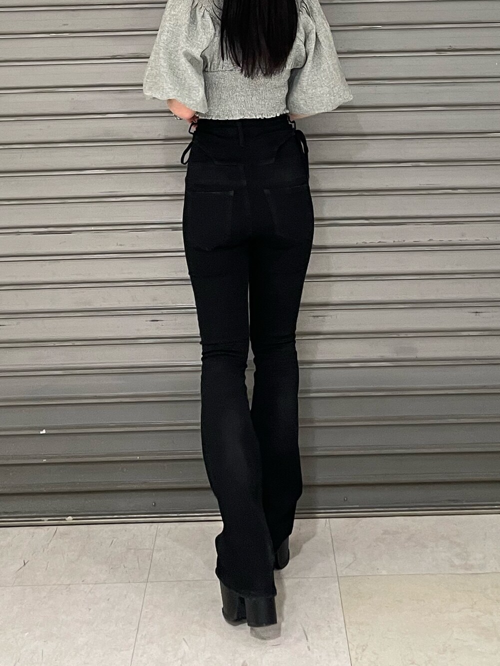 グレー系のTシャツ/カットソー、ブラック系のデニムパンツ、ブラック系のサンダルを着用したレディースの春コーディネートの5枚目の写真