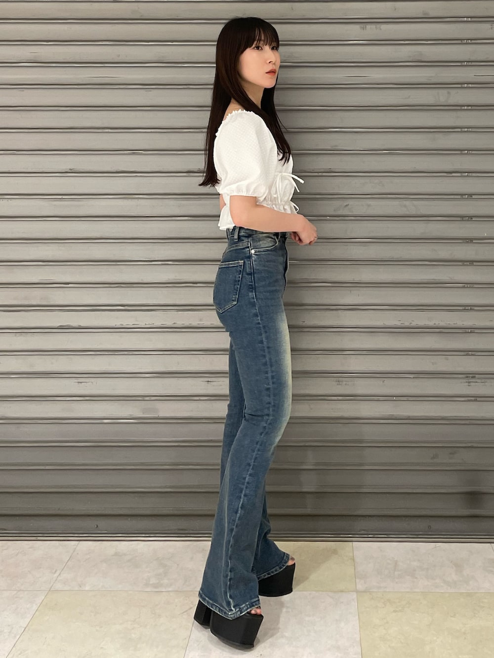 ホワイト系のTシャツ/カットソー、ブルー系のサロペット/オーバーオール、ブラック系のサンダルを着用したレディースの春コーディネートの2枚目の写真