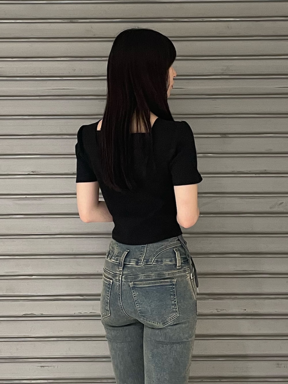 ブラック系のTシャツ/カットソー、ブルー系のデニムパンツ、ブラック系のサンダルを着用したレディースの春コーディネートの6枚目の写真