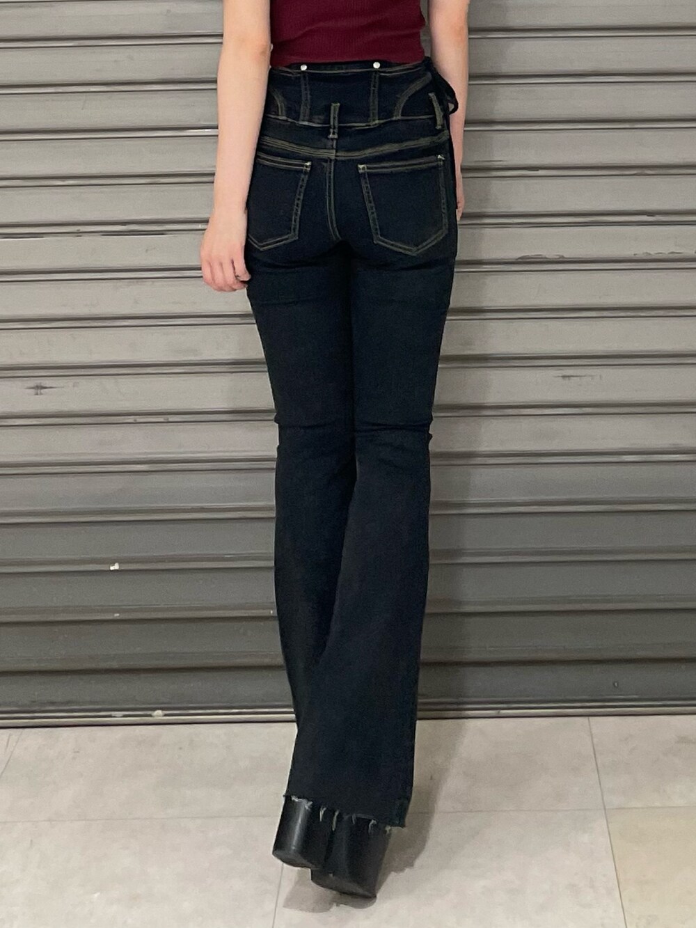 レッド系のTシャツ/カットソー、ブラック系のサンダル、ブルー系のデニムパンツを着用したレディースの夏コーディネートの6枚目の写真