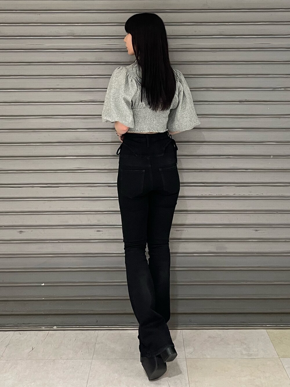 グレー系のTシャツ/カットソー、ブラック系のデニムパンツ、ブラック系のサンダルを着用したレディースの春コーディネートの4枚目の写真