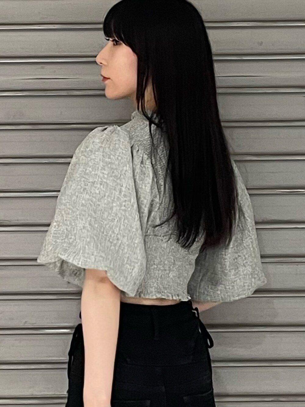 グレー系のTシャツ/カットソー、ブラック系のデニムパンツ、ブラック系のサンダルを着用したレディースの春コーディネートの6枚目の写真