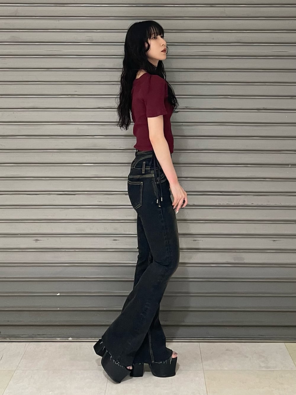 レッド系のTシャツ/カットソー、ブラック系のサンダル、ブルー系のデニムパンツを着用したレディースの夏コーディネートの2枚目の写真